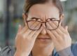 Frau mit Brille reibt sich die Augen zum Thema Glaskörpertrübung, Mouches volantes